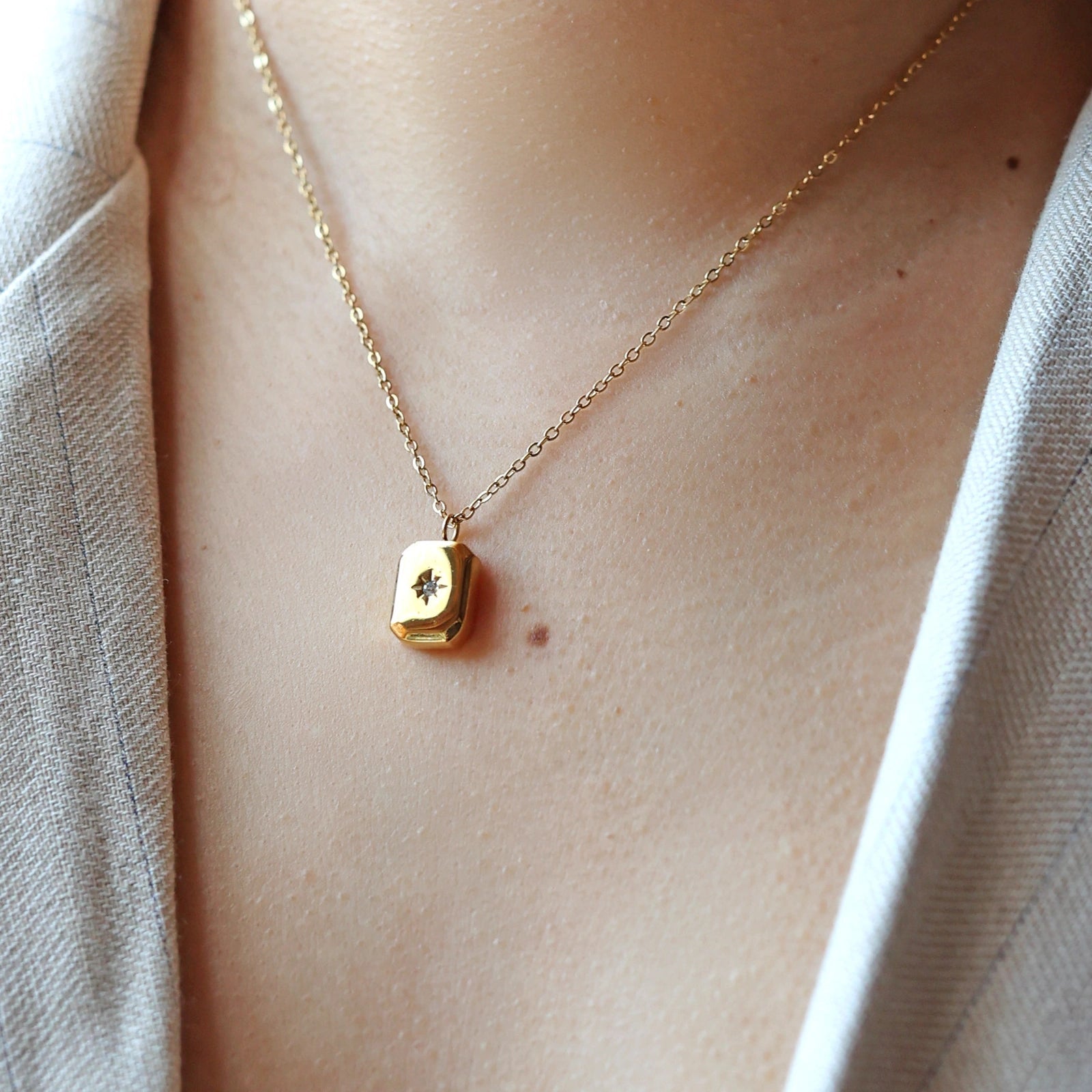Collier "Ma voie" porté au cou, avec pendentif rectangulaire en acier doré personnalisé.