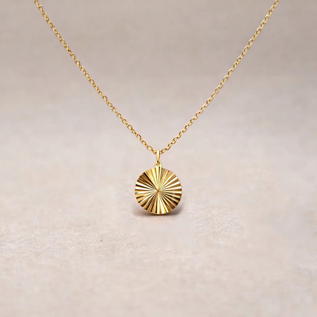 Zoom sur le collier "Energie" avec pendentif rond strié personnalisable au dos en acier doré.