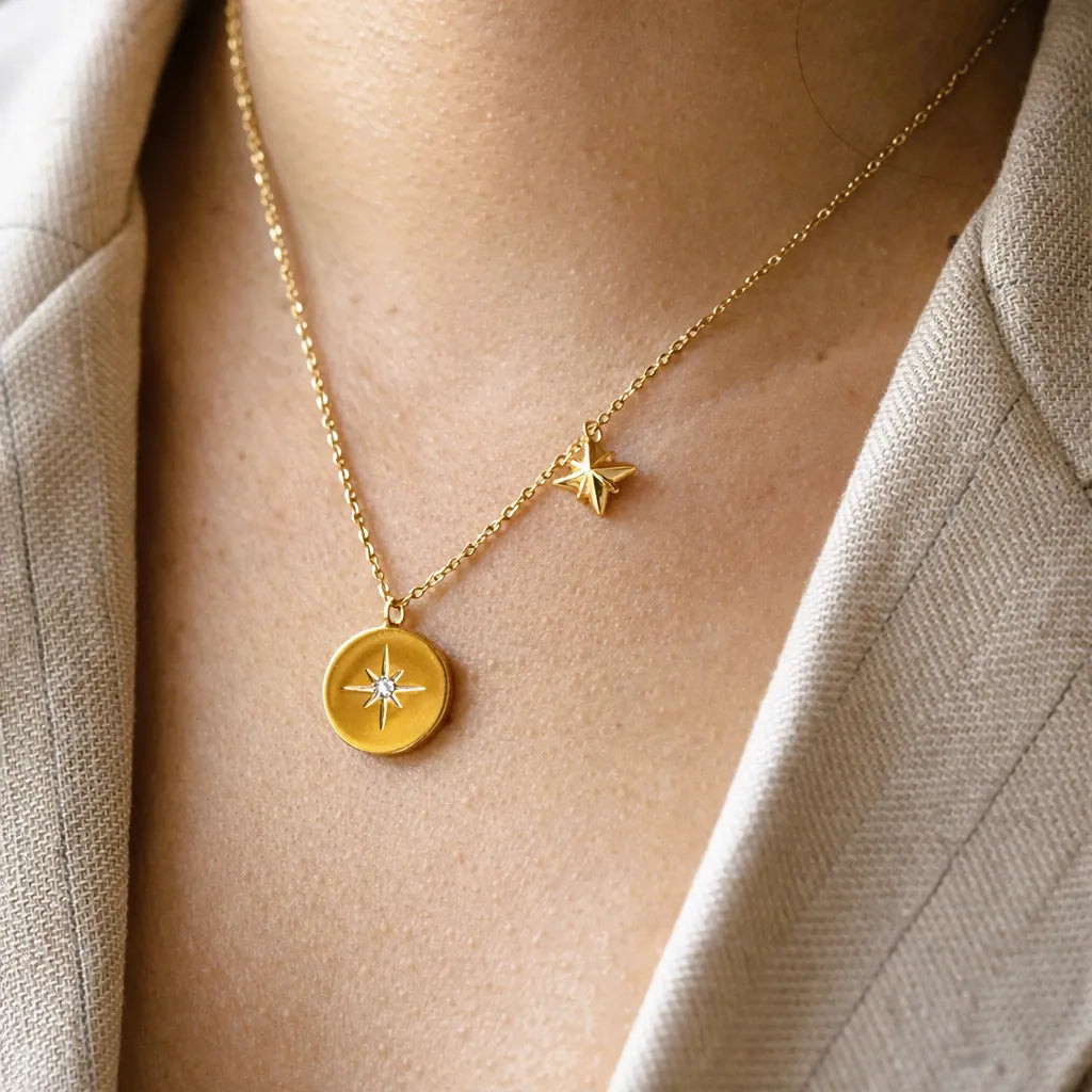 Collier Etincelle en acier doré avec pendentif rond orné d'une étoile et d'un cristal brillant, porté autour du cou. Face visible, verso personnalisable.