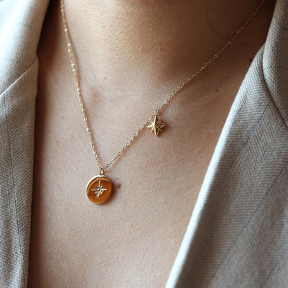 Collier Mon rêve en acier doré avec pendentif rond orné d'une étoile et d'un zircon, porté autour du cou. Face visible, verso personnalisable.