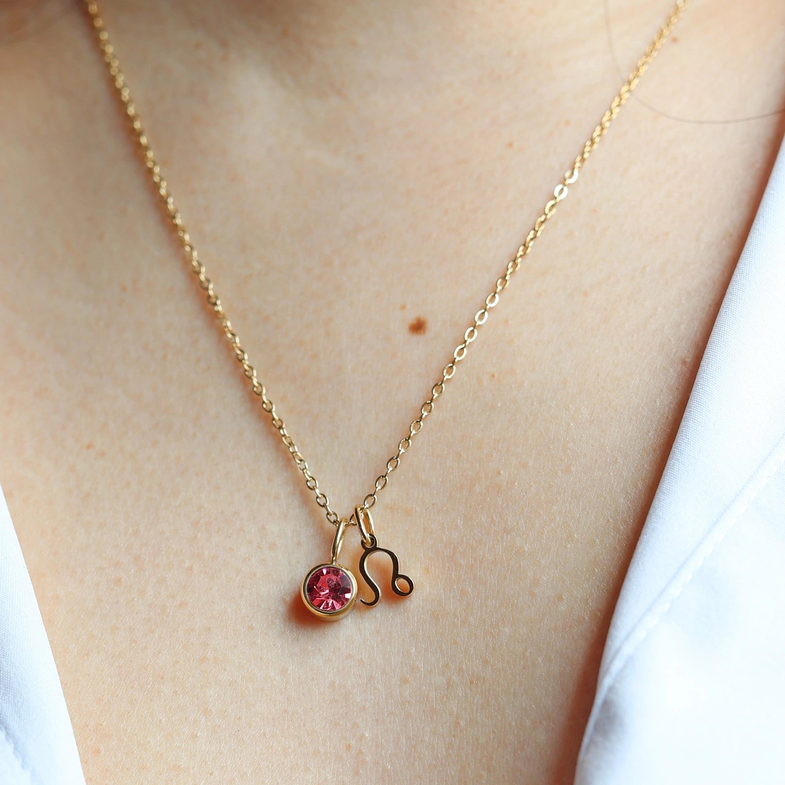 Collier "Mon identité" en acier doré, avec signe du zodiaque et pierre de couleur, porté autour du cou.