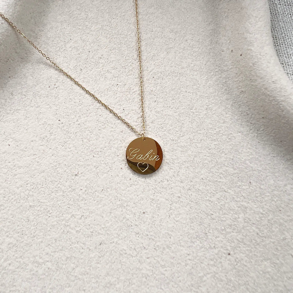 Zoom sur le collier "Reflet" avec médaille ronde personnalisé "Gabin" en acier inoxydable rosé.