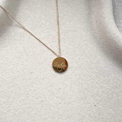 Zoom sur le collier "Reflet" avec médaille ronde personnalisé "Gabin" en acier inoxydable rosé.