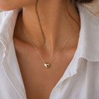 Collier Authentique avec pendentif cœur minimaliste en acier inoxydable doré, porté autour du cou.