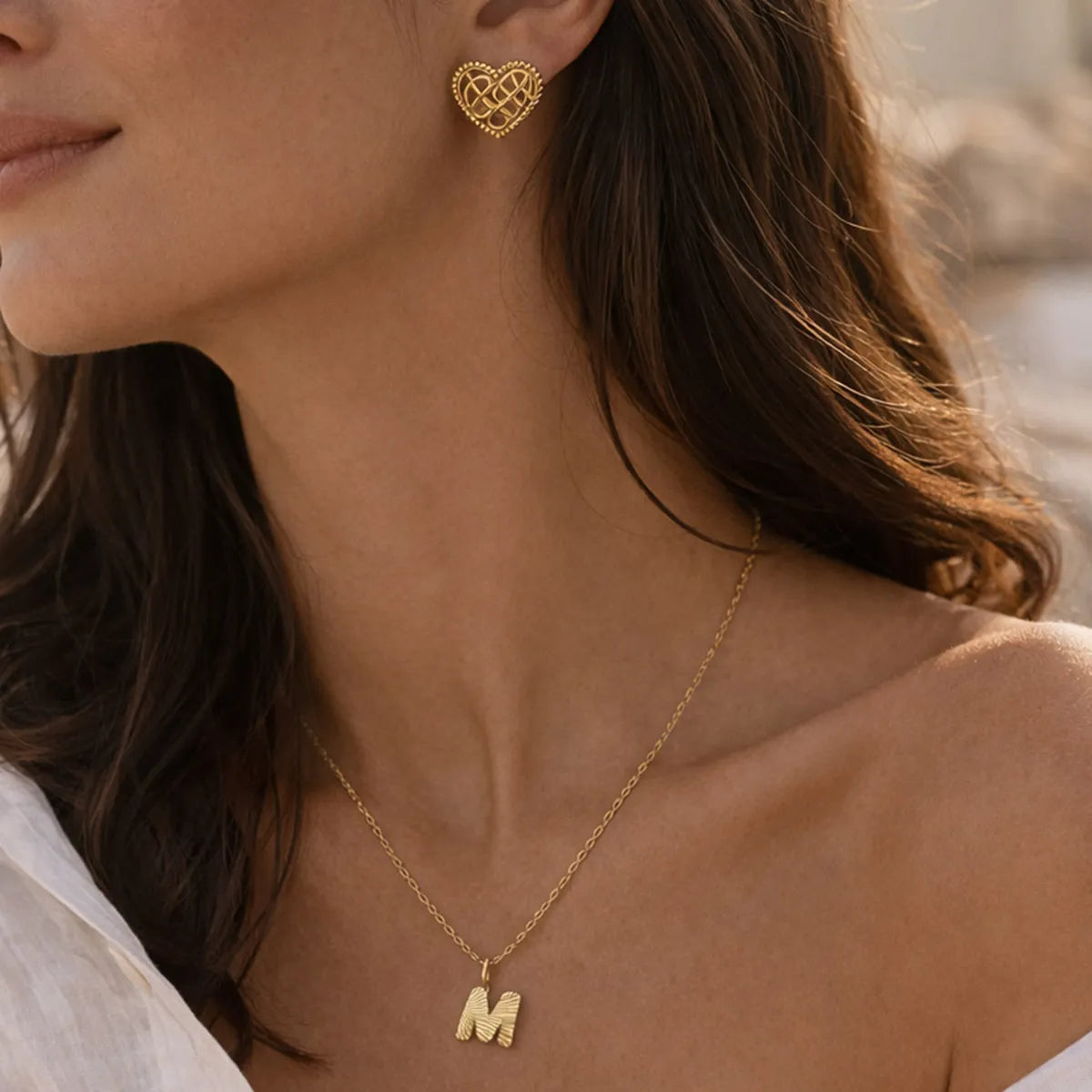 Coffret Évidence – Collier initiale & boucles cœur tressé Visée Bijoux, portés sur une belle mannequin.