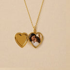 Zoom sur le collier Précieux, médaillon cœur en acier doré avec gravure et  photo d'une mère et de son enfant, souvenir à personnaliser, posé sur un fond beige texturé.