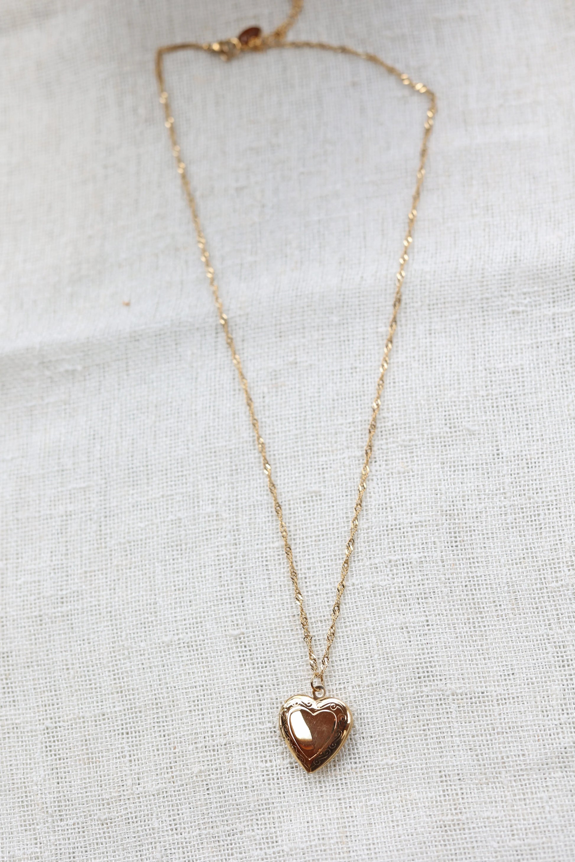 Collier médaillon cœur MANON en acier inoxydable doré, personnalisable pour y insérer des photos souvenirs.