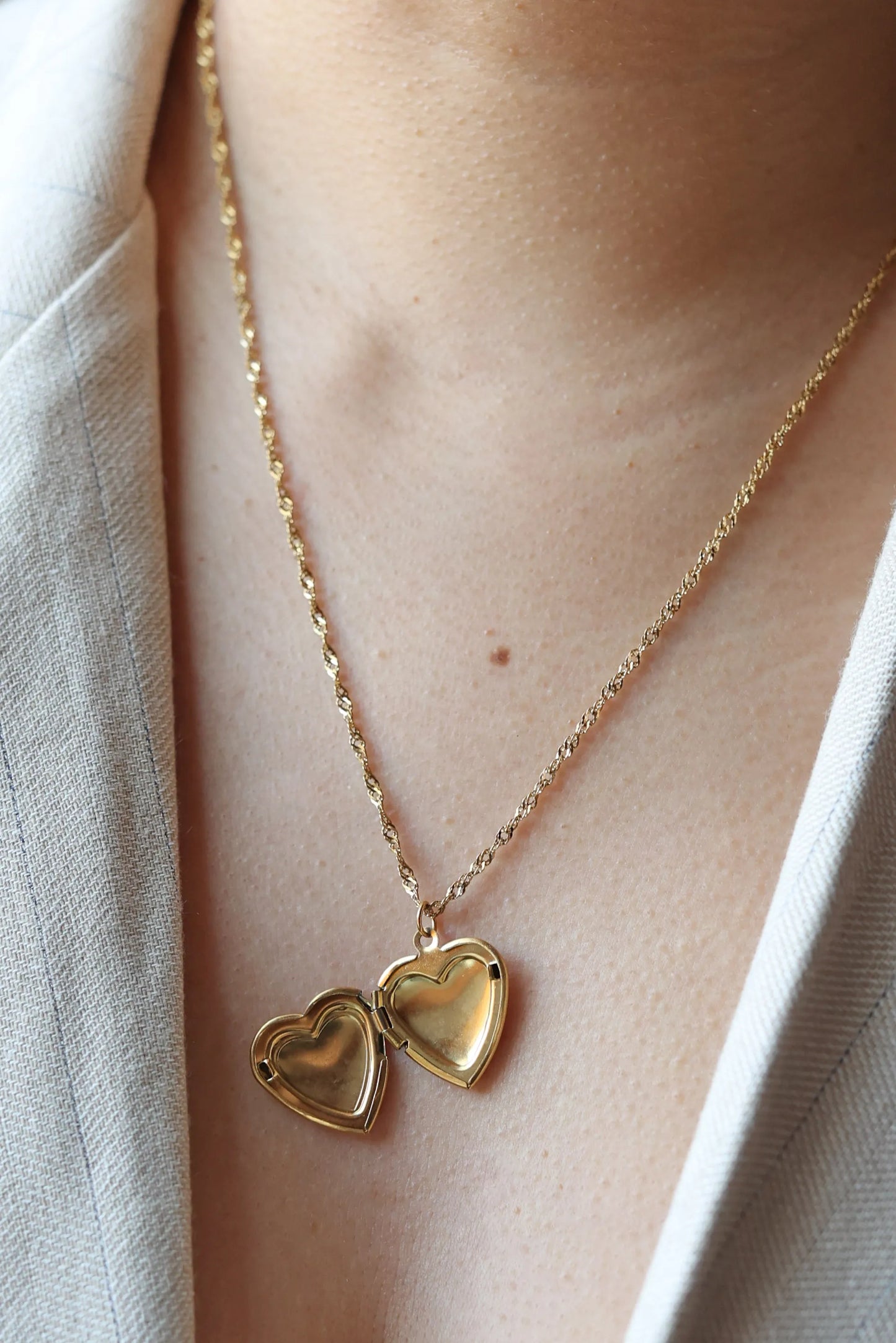 Collier médaillon cœur MANON en acier inoxydable doré, personnalisable pour y insérer des photos souvenirs.