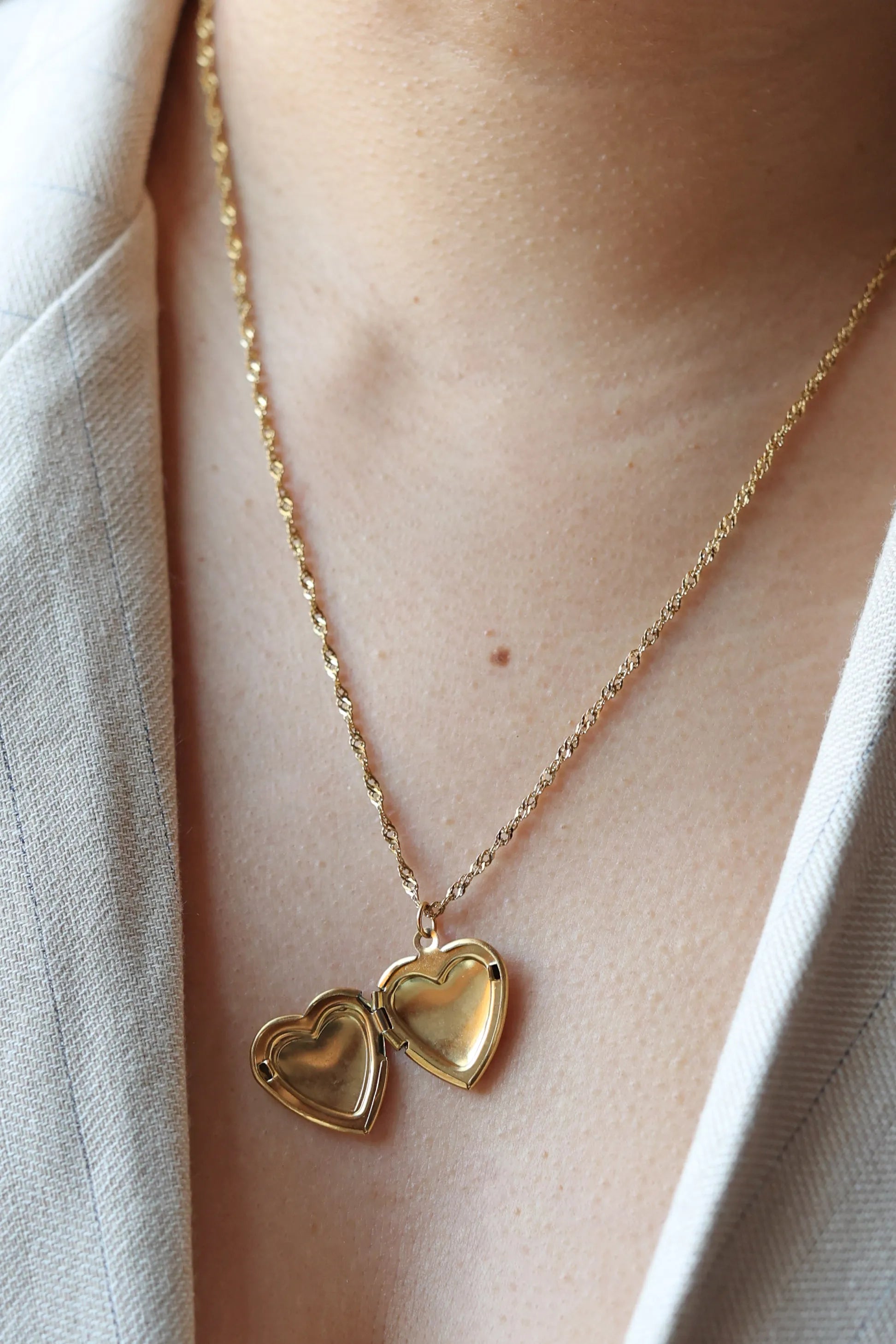 Collier médaillon cœur MANON en acier inoxydable doré, personnalisable pour y insérer des photos souvenirs.