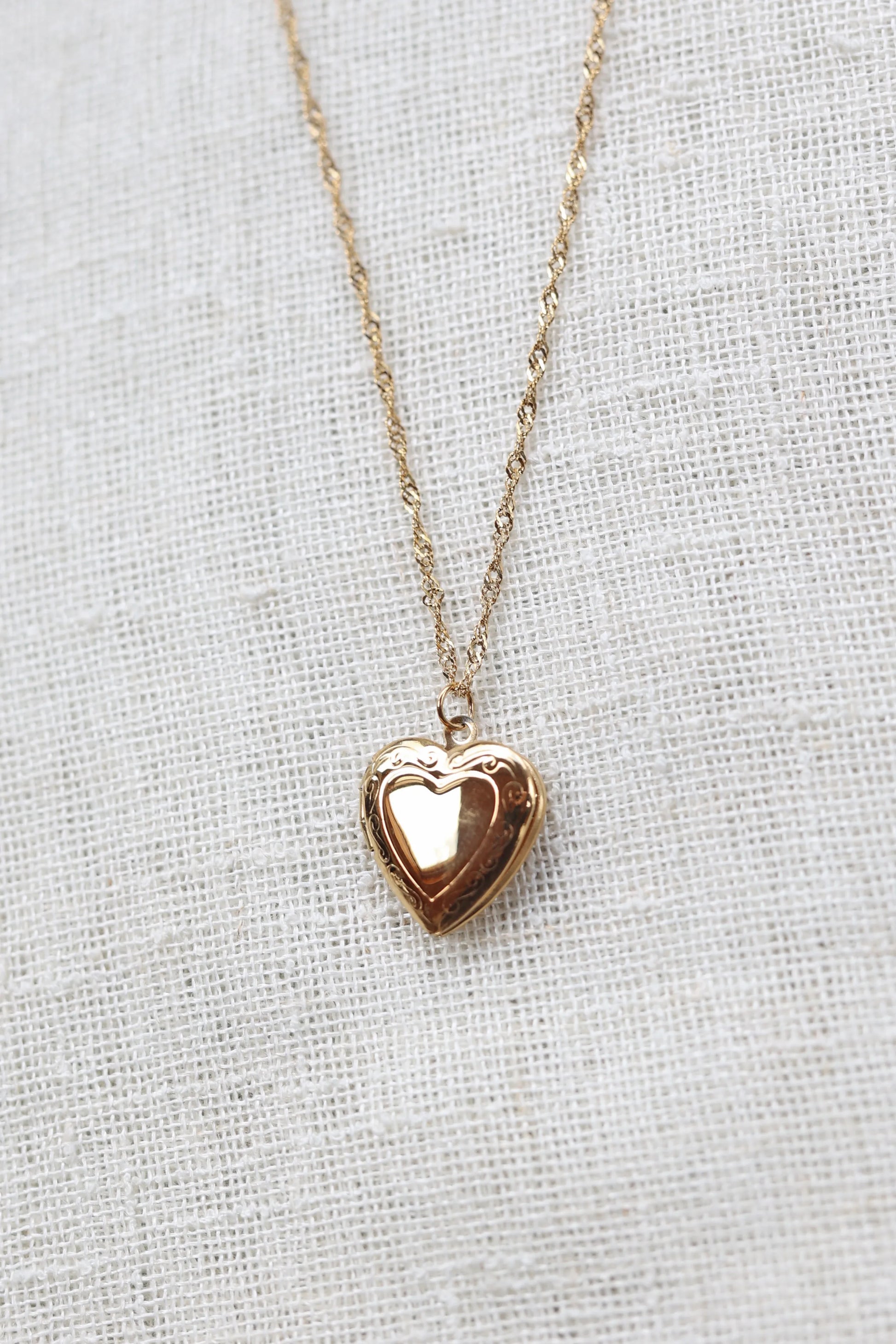 Collier médaillon cœur MANON en acier inoxydable doré, personnalisable pour y insérer des photos souvenirs.