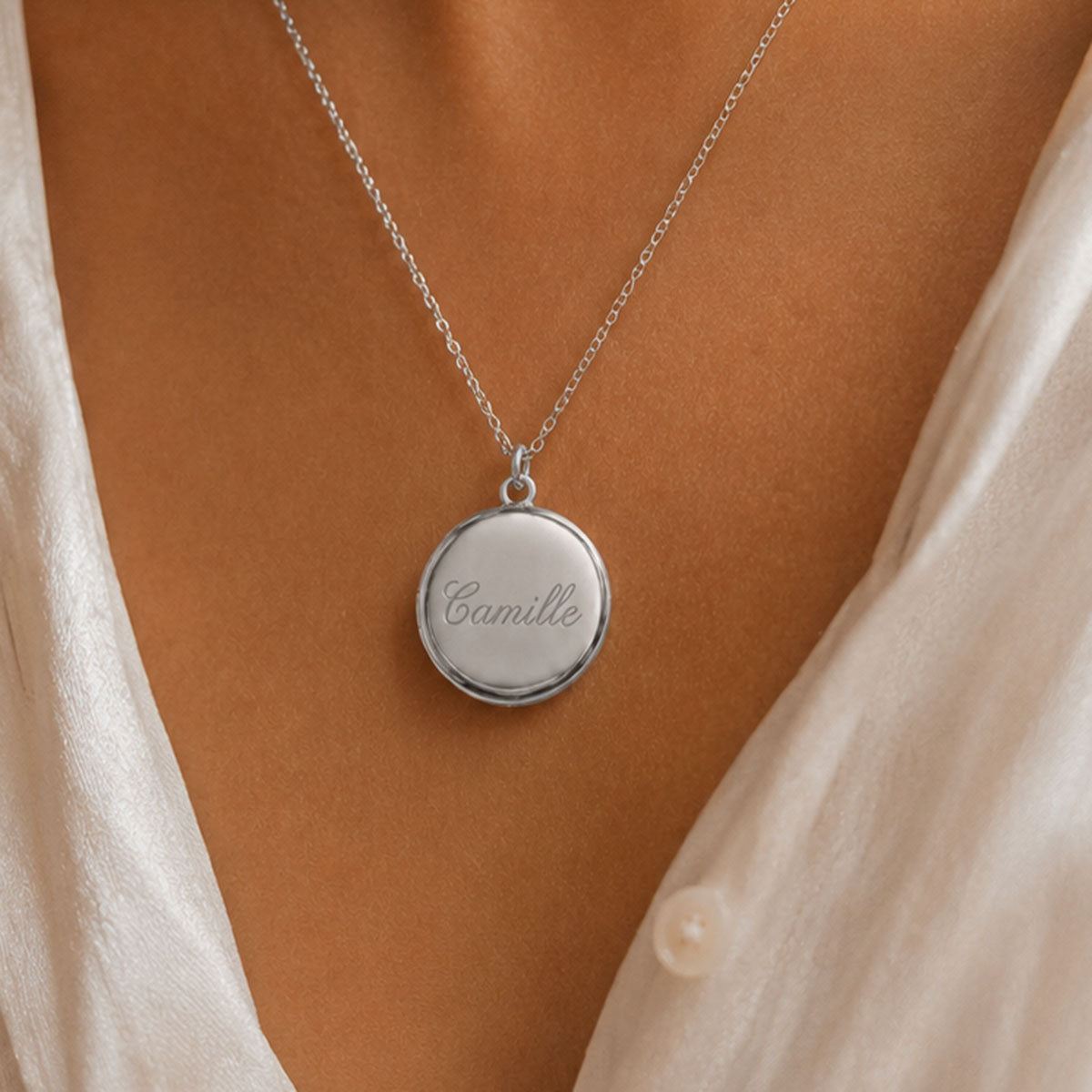 Collier médaillon photo rond argenté minimaliste porté au cou gravé du prénom Camille  à la pointe de diamant