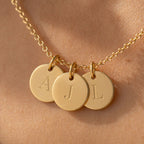 Collier Inspiration en acier doré, 3 médaillons personnalisables gravés en macro avec les initiales A j et L, porté sur peau 