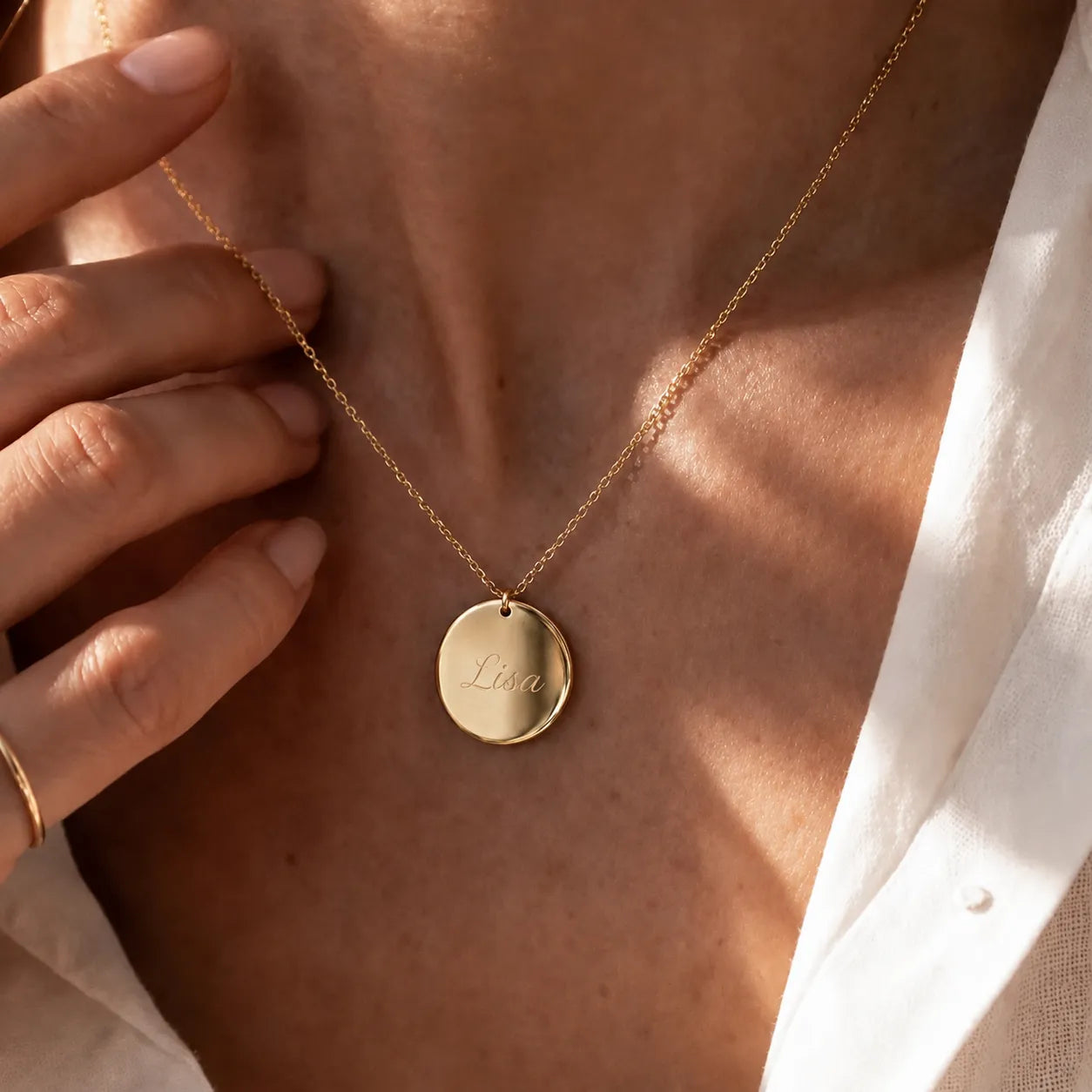 Collier médaille ronde personnalisable au recto et verso avec prénom, initiales et dates en dorée, portée sur une mannequin— Reflet Visée Bijoux