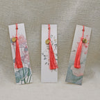 Trois marque-page Visée Bijoux à motifs floraux avec médaillon et pompon.