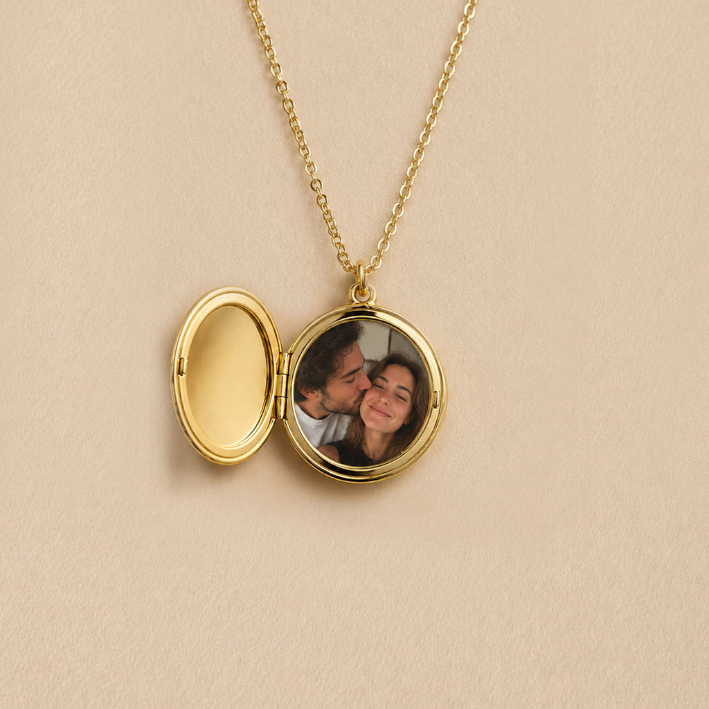 Médaillon rond doré ouvert, photo d'un couple, insérée à l'intérieur