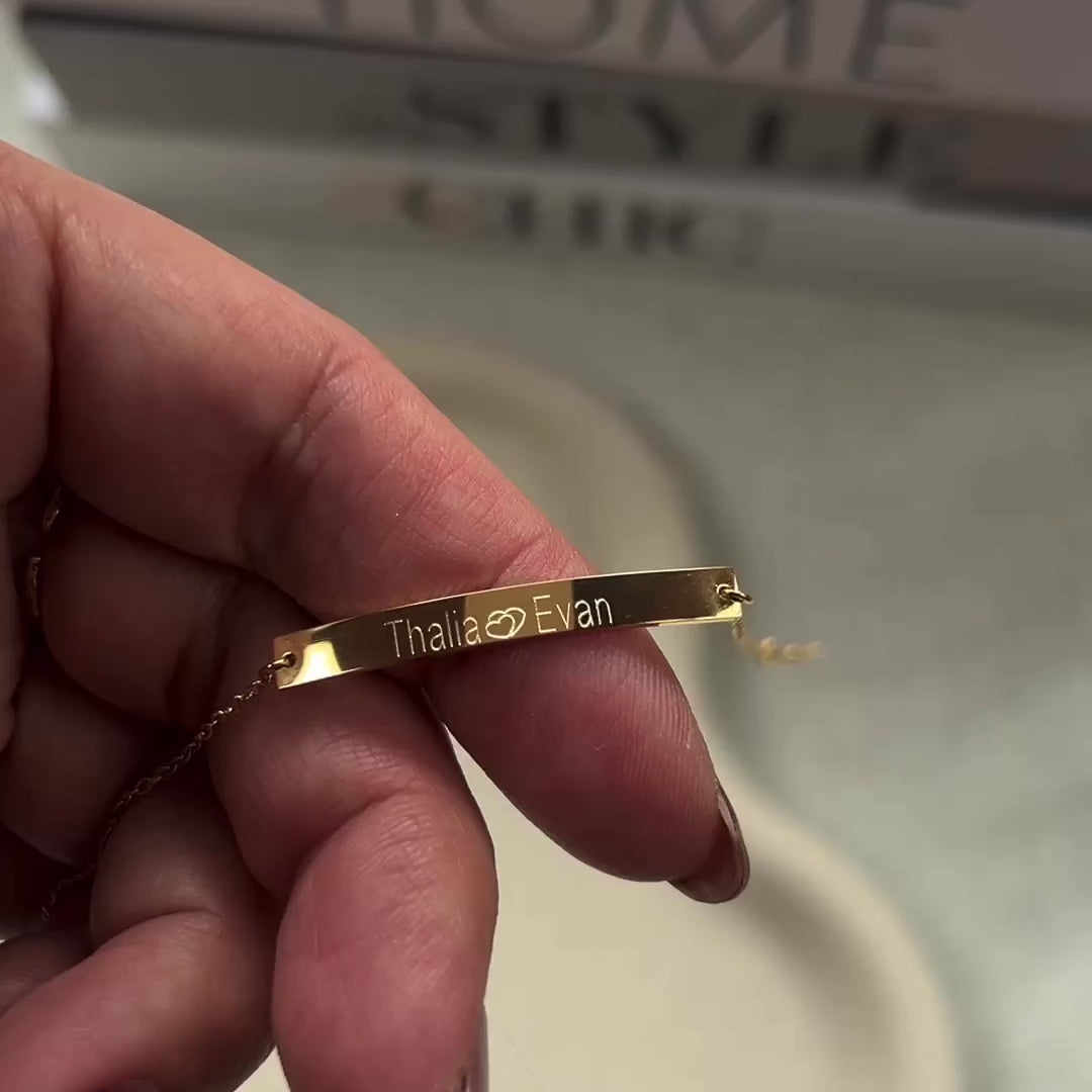 Vidéo du bracelet gourmette "Sincérité" en acier inoxydable doré,  personnalisable, gravé avec les prénoms Thalia et Evan