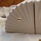 Vidéo du collier Authentique avec pendentif cœur personnalisable, en acier inoxydable doré, en vue d'ensemble sur un fond beige texturé.