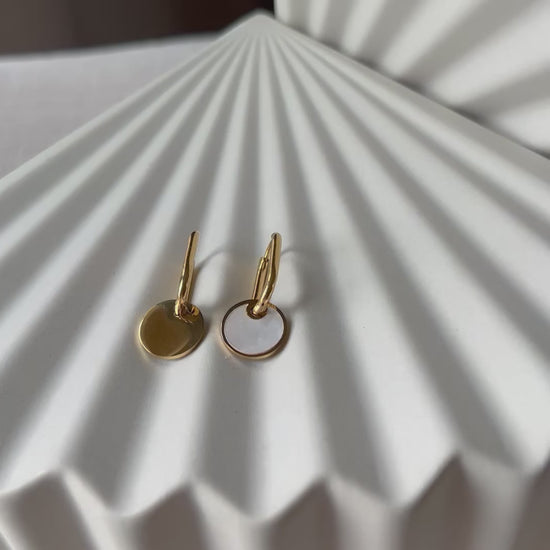 Vidéo des boucles d'oreilles "Solstice", en acier doré, pendentifs cercles personnalisables à effet nacré.