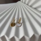 Vidéo des boucles d'oreilles "Solstice", en acier doré, pendentifs cercles personnalisables à effet nacré.