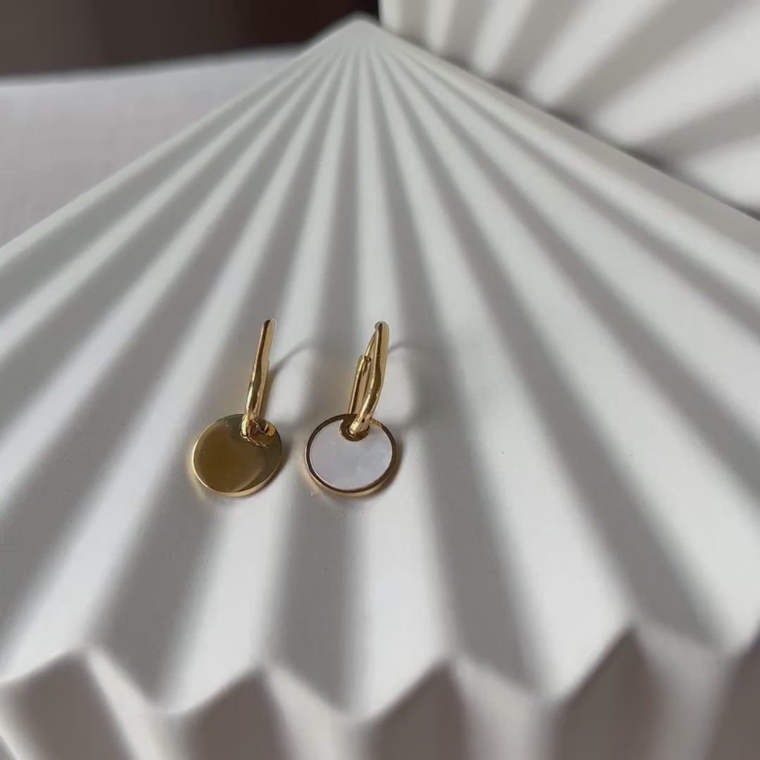Vidéo des boucles d'oreilles "Solstice", en acier doré, pendentifs cercles personnalisables à effet nacré.