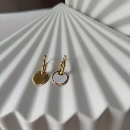 Vidéo des boucles d'oreilles "Solstice", en acier doré, pendentifs cercles personnalisables à effet nacré.