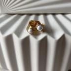 Vidéo de la bague Rencontre ouverte en acier inoxydable doré, ornée de deux perles blanches.