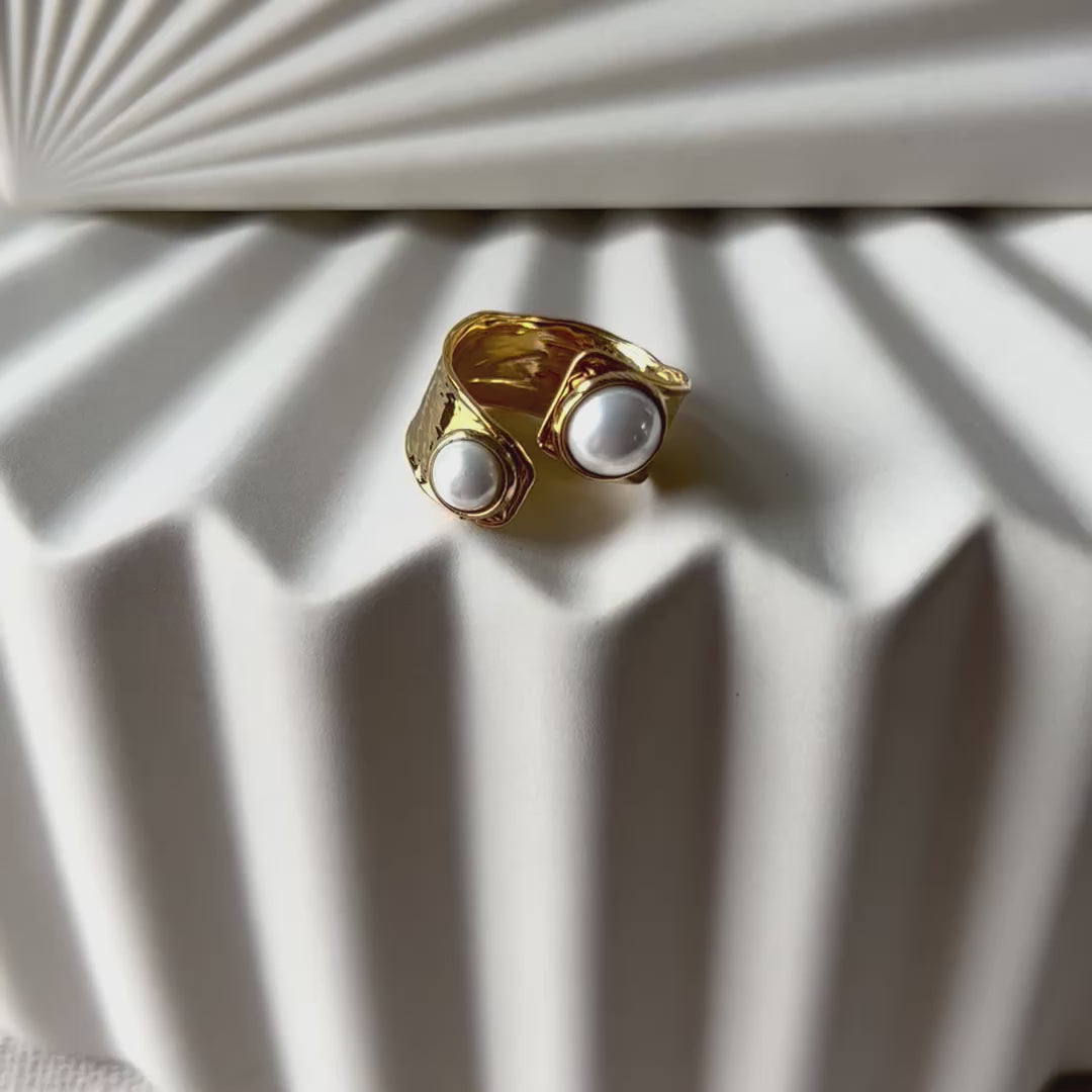Vidéo de la bague Rencontre ouverte en acier inoxydable doré, ornée de deux perles blanches.
