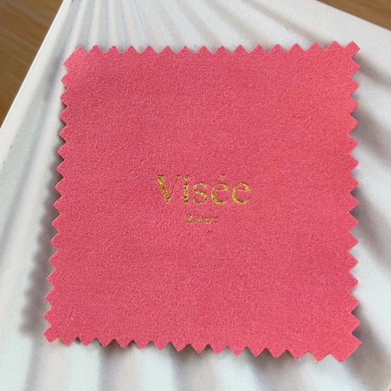 Vidéo de la chamoisine Visée en suédine corail, pour l'entretien délicat des bijoux, photographiée sur un fond beige.