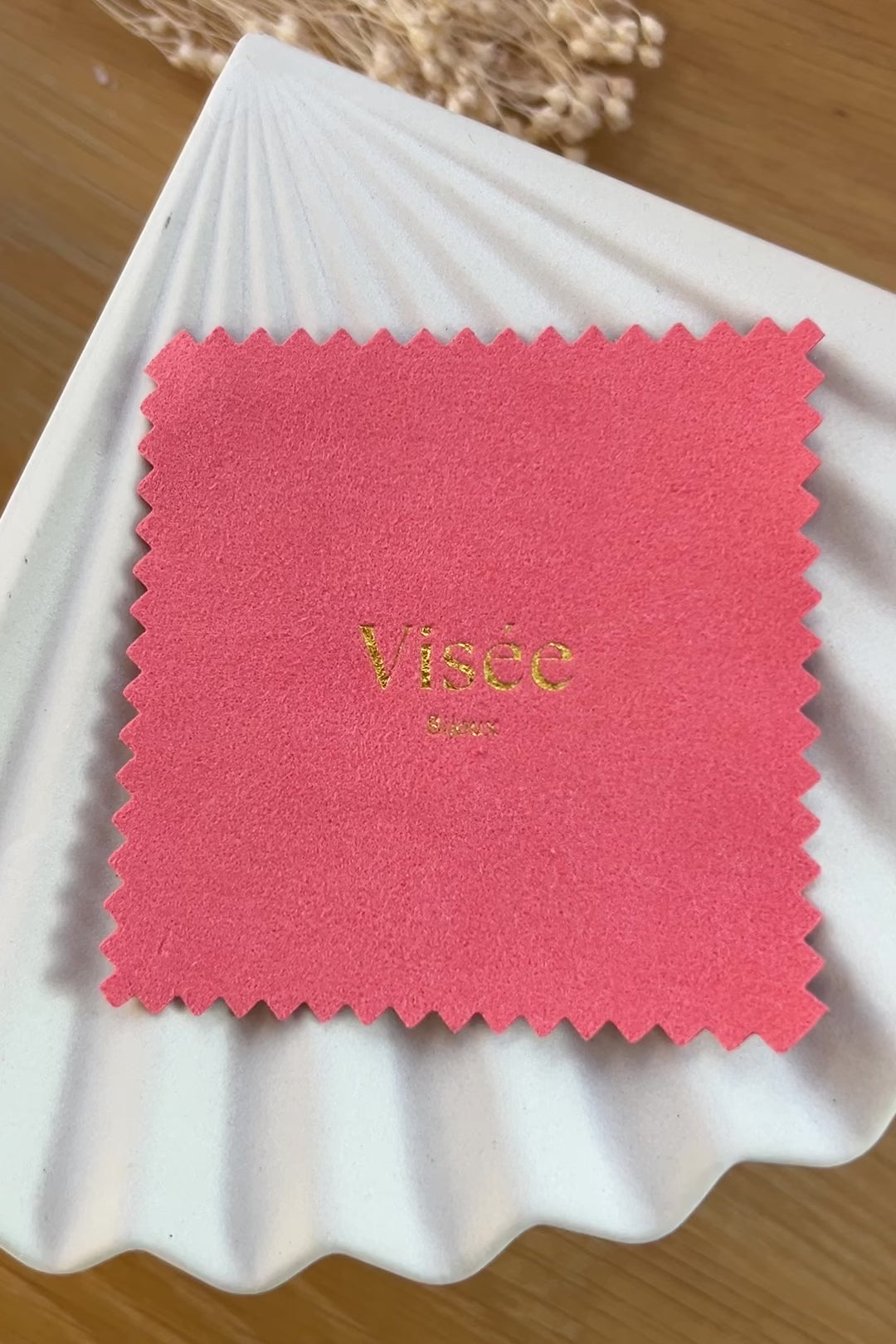 Vidéo de la chamoisine Visée en suédine corail, pour l'entretien délicat des bijoux, photographiée sur un fond beige.