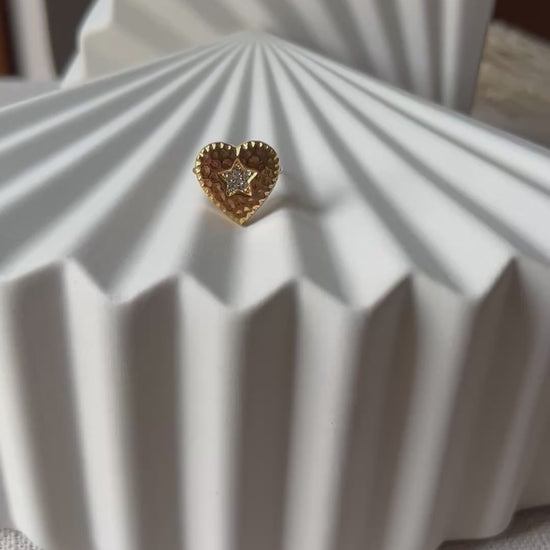 Vidéo de la bague ajustable Coeur battant, en acier doré en forme de cœur finement martelé, ornée d'une étoile brillante au centre.
