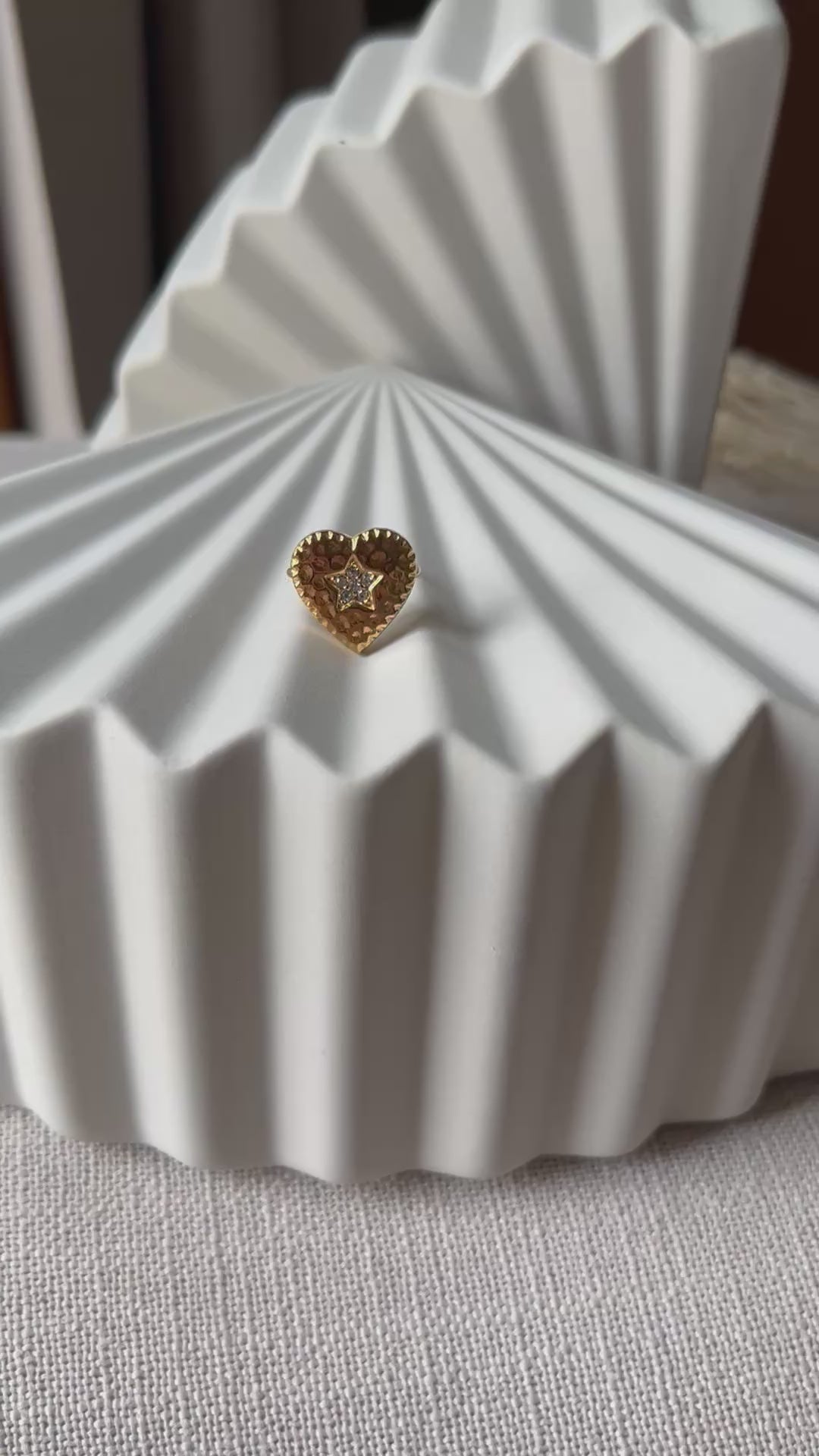 Vidéo de la bague ajustable Coeur battant, en acier doré en forme de cœur finement martelé, ornée d'une étoile brillante au centre.