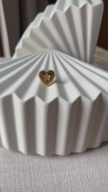 Vidéo de la bague ajustable Coeur battant, en acier doré en forme de cœur finement martelé, ornée d'une étoile brillante au centre.