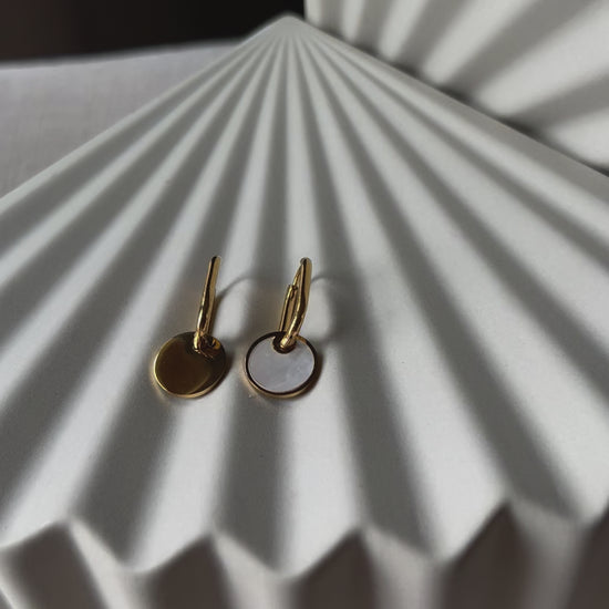 Vidéo des boucles d'oreilles "Solstice", en acier doré, pendentifs cercles personnalisables à effet nacré.