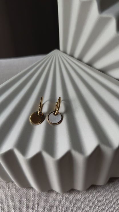 Vidéo des boucles d'oreilles "Solstice", en acier doré, pendentifs cercles personnalisables à effet nacré.