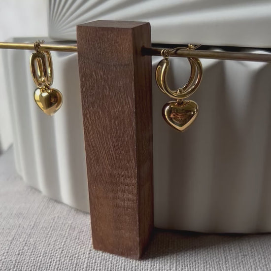 Vidéo des boucles d'oreilles "Amour suspendu" de Visée, avec pendentifs cœurs en acier doré.