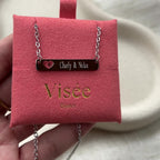 Vidéo du collier "Touchante" avec plaque personnalisable en acier argenté avec cœur découpé, gravé aux noms de Charly et Nolan