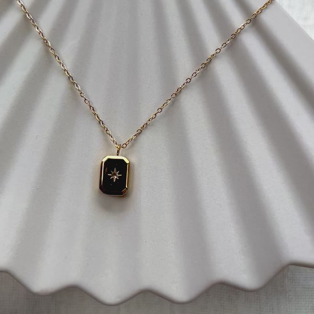 Vidéo du collier "Ma voie" avec pendentif rectangulaire personnalisable en acier doré, sur fond beige texturé.