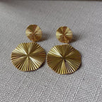 Vidéo des boucles d'oreilles Vivante pendantes au design solaire strié en acier inoxydable doré.