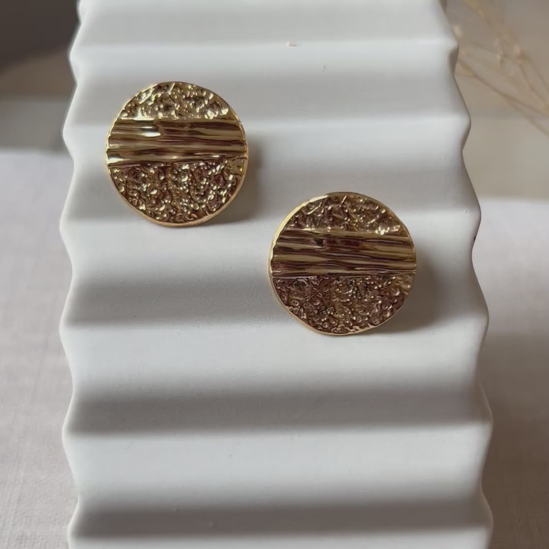 Vidéo des boucles d'oreilles Rayonnante, en acier inoxydable doré, au design rond texturé et éclatant.
