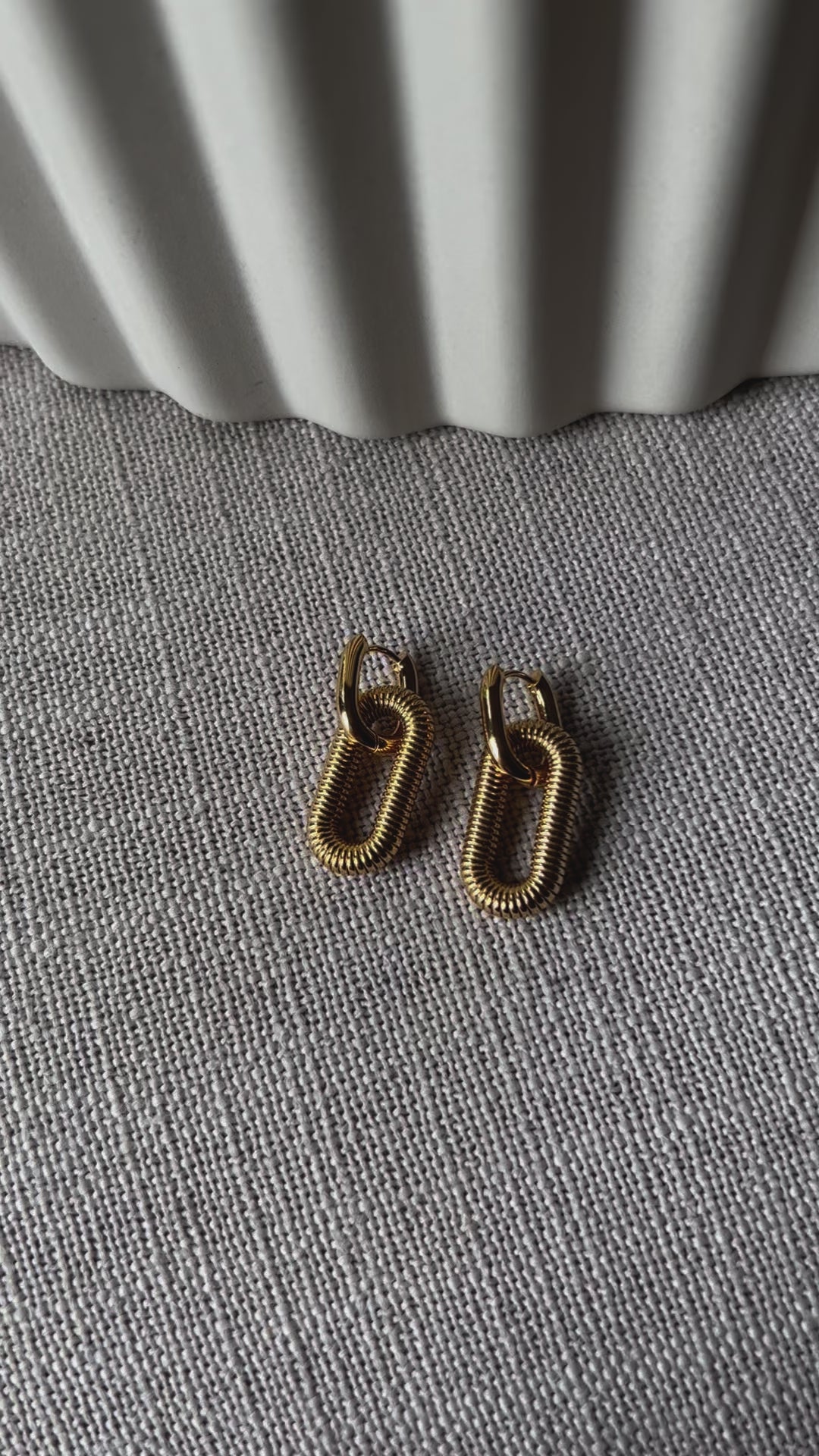 Boucles d'oreilles "J'existe" en acier doré, au design modulable.