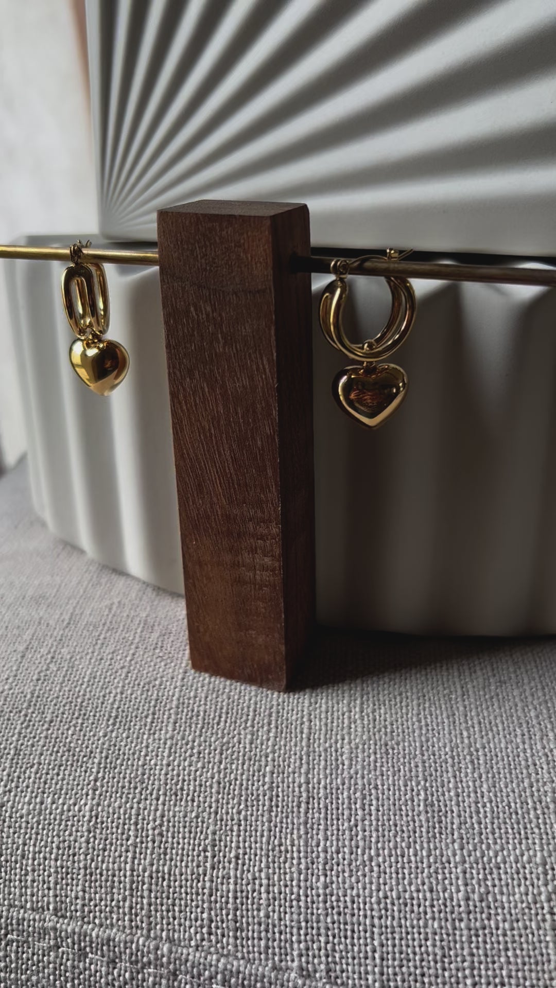 Vidéo des boucles d'oreilles "Amour suspendu" de Visée, avec pendentifs coeurs en acier doré.