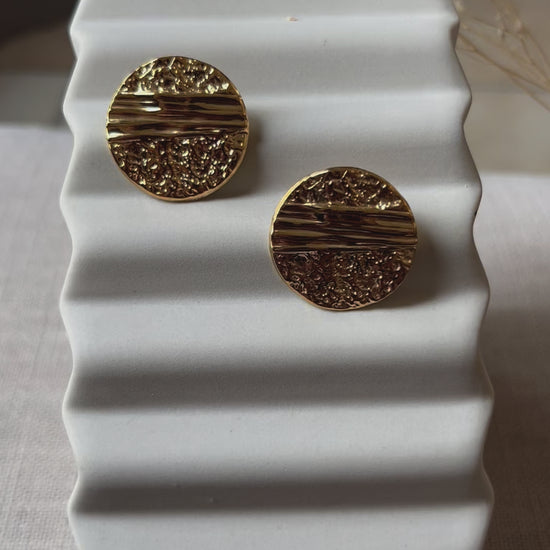 Vidéo des boucles d'oreilles Rayonnante, en acier inoxydable doré, au design rond texturé et éclatant.
